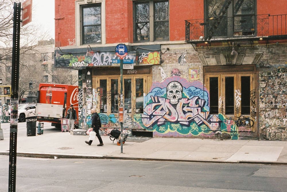 A mural-covered storefront corner at St. Marks Place and Avenue A, East Village