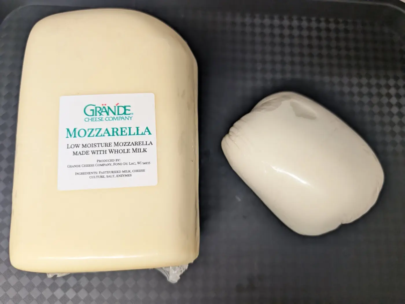 A block of Grande whole-milk, low-moisture mozzarella beside a smaller ball of fresh mozzarella