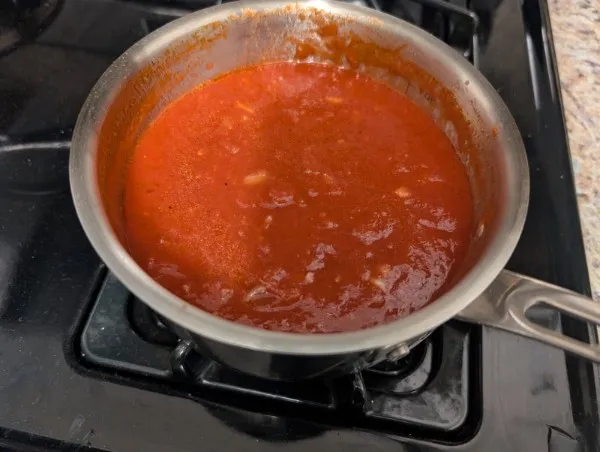 Homemade tomato sauce in a stainless steel saucepan on the stove