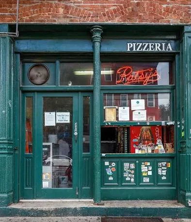 Patsy's Pizzeria on First Avenue in East Harlem: a green storefront with a red neon Patsy's sign in the window under a PIZZERIA sign