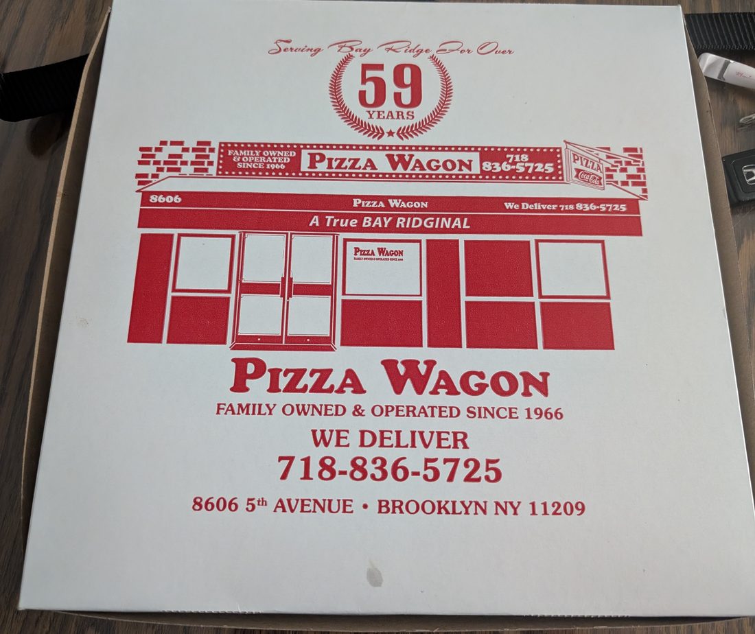 A Pizza Wagon box printed with the storefront and the words Serving Bay Ridge For Over 59 Years.
