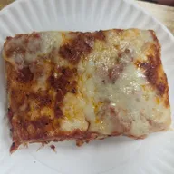 A thick Sicilian square slice on a paper plate